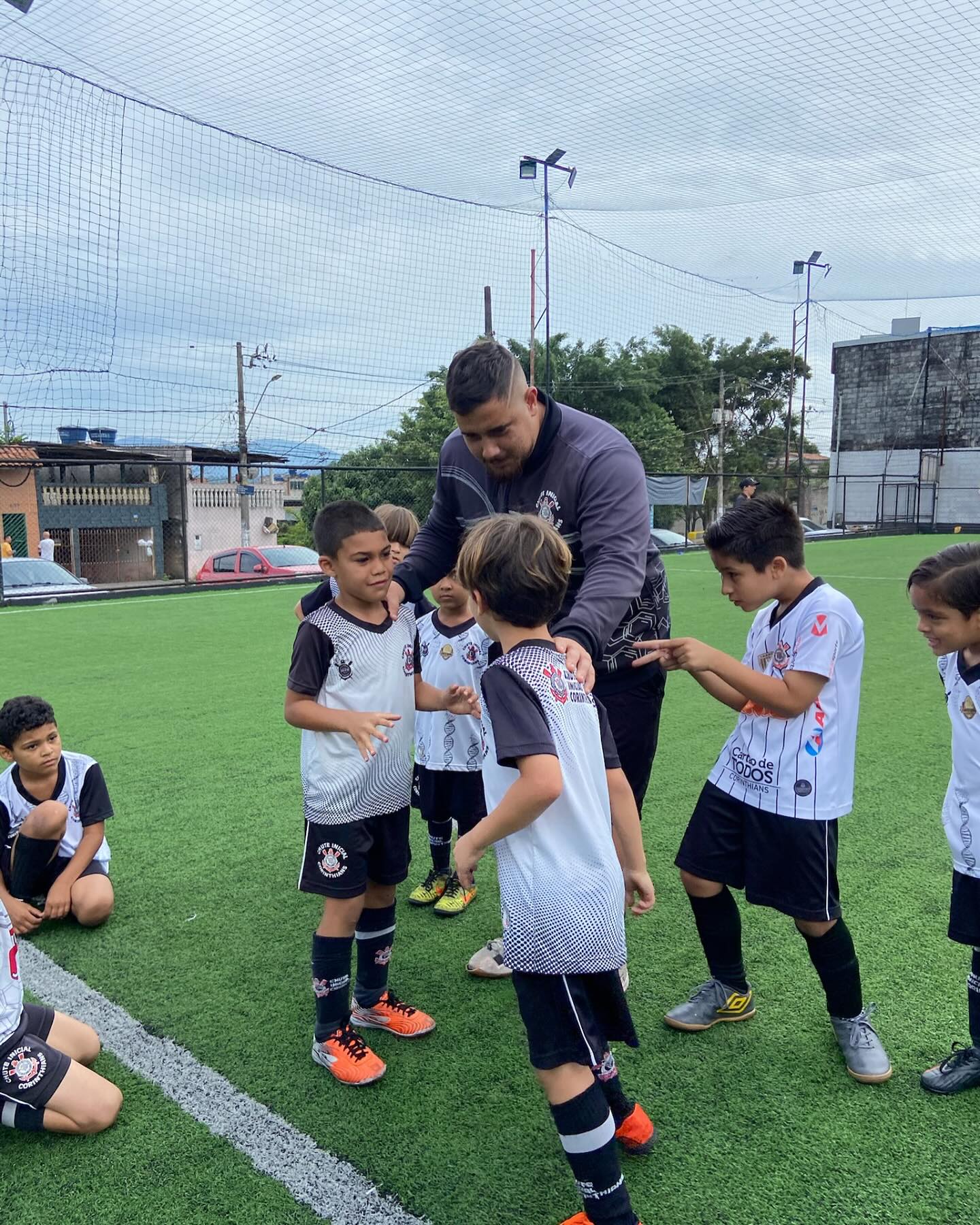 Professor conversando com alunos em campo